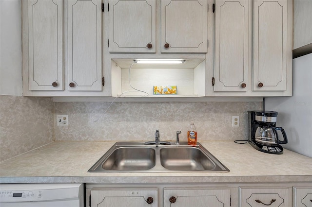 kitchen with white dishwasher, sink, and tasteful backsplash