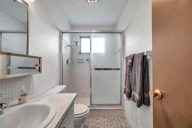 bathroom featuring vanity, toilet, an enclosed shower, and decorative backsplash