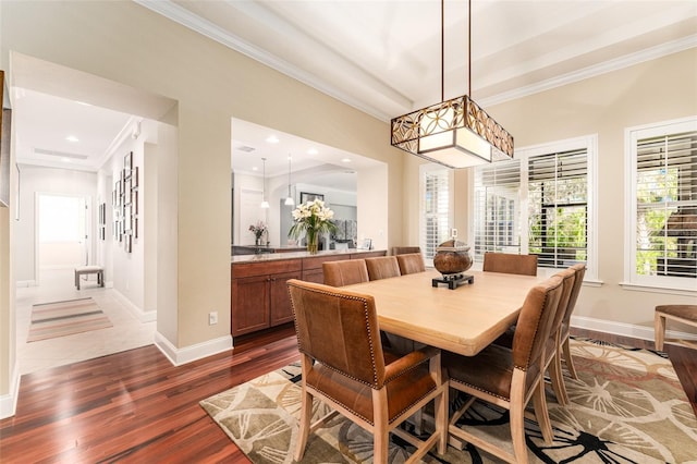 dining space featuring dark wood-type flooring and crown molding