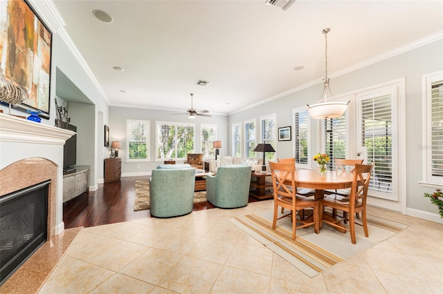 tiled dining room featuring ceiling fan and ornamental molding