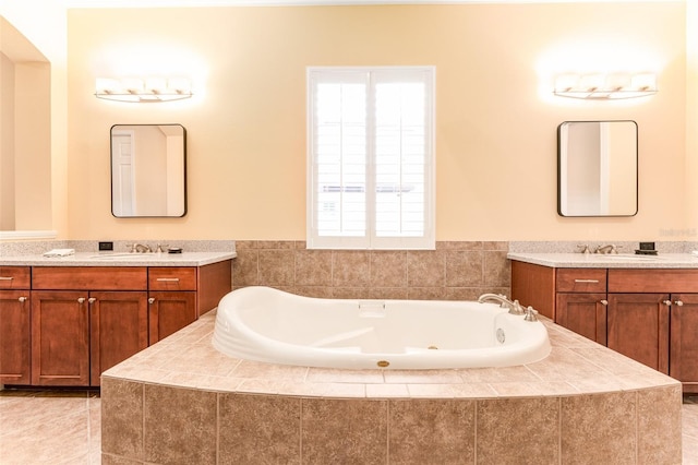 bathroom with vanity, tile patterned floors, and tiled bath