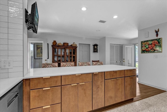 kitchen featuring dark hardwood / wood-style floors, kitchen peninsula, and dishwasher