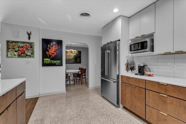 kitchen with tasteful backsplash, stainless steel appliances, and white cabinets