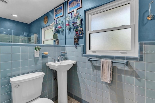 bathroom featuring tile walls and toilet