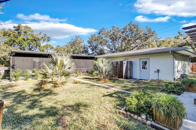 back of property featuring a lawn and a sunroom