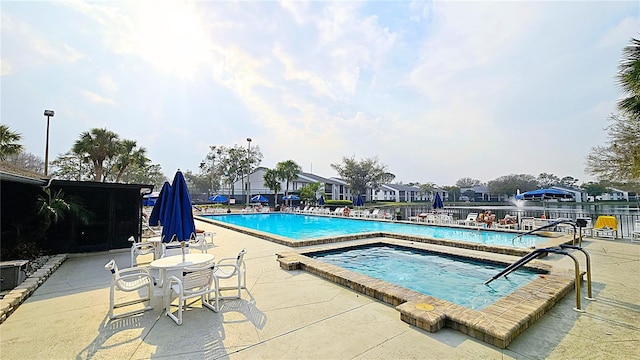 view of pool featuring a hot tub and a patio