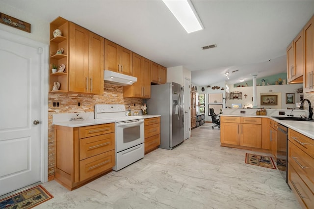 kitchen featuring lofted ceiling, sink, tasteful backsplash, kitchen peninsula, and stainless steel appliances