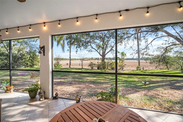 unfurnished sunroom featuring track lighting and a rural view