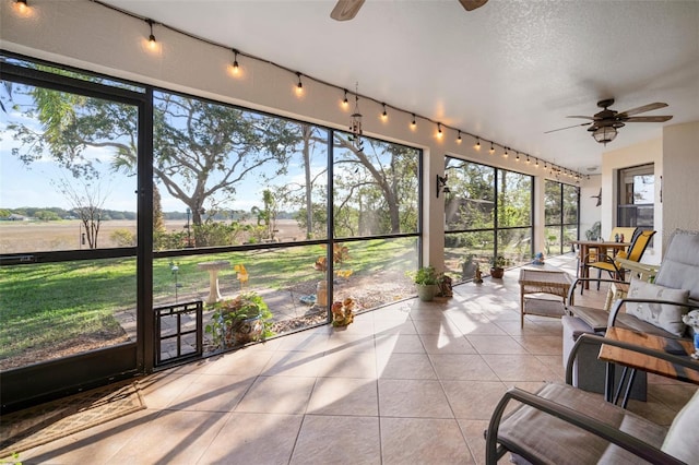 sunroom featuring ceiling fan and track lighting