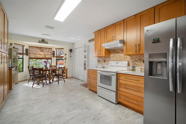1472 Ivydale Rd, Spring Hill, FL 34606 - kitchen with stainless steel fridge, white range with electric cooktop, under cabinet range hood, decorative backsplash, and light marble finish floors
