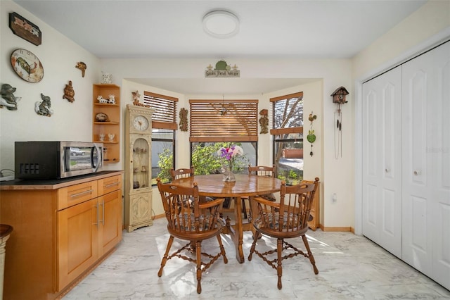 1472 Ivydale Rd, Spring Hill, FL 34606 - dining space featuring light marble finish floors and baseboards