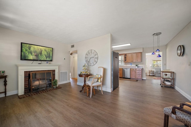 living room with dark wood-type flooring and a brick fireplace