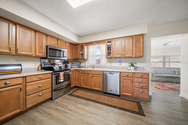 kitchen with sink, stainless steel appliances, and light wood-type flooring