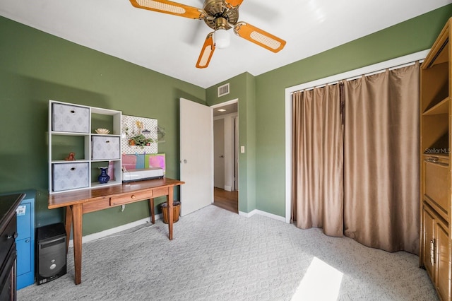 home office featuring light carpet and ceiling fan