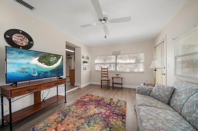 living room featuring wood-type flooring and ceiling fan