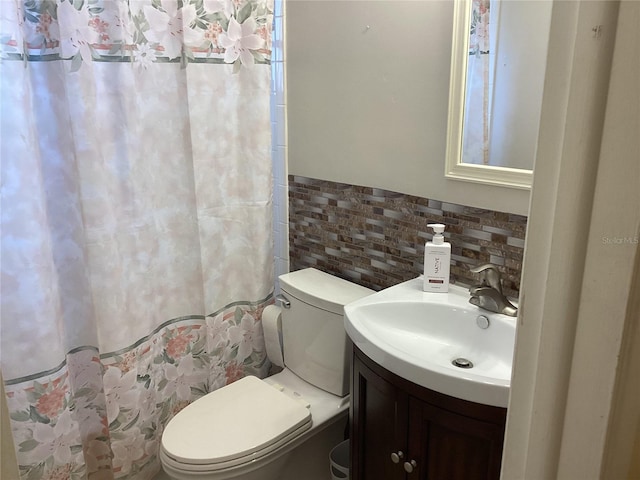 bathroom featuring vanity, tile walls, and toilet