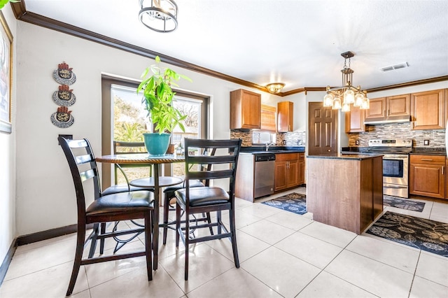 kitchen with stainless steel appliances, a kitchen island, backsplash, and decorative light fixtures