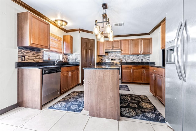 kitchen with light tile patterned floors, ornamental molding, a center island, and appliances with stainless steel finishes