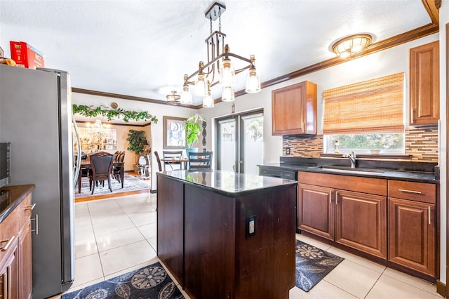 kitchen with light tile patterned flooring, sink, stainless steel refrigerator, and decorative backsplash