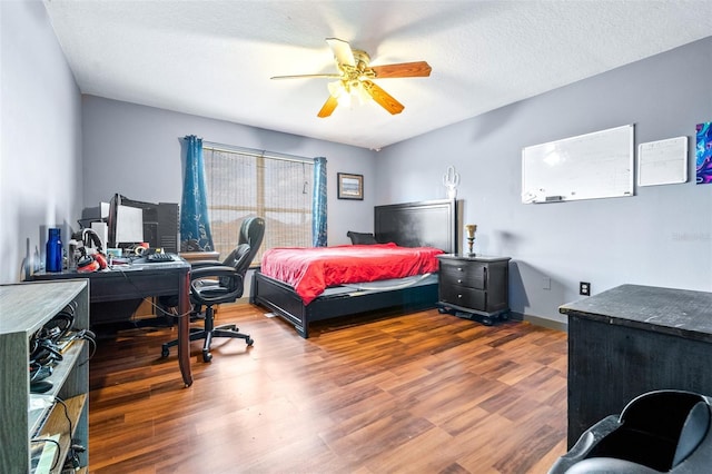 bedroom with dark wood-type flooring, ceiling fan, and a textured ceiling