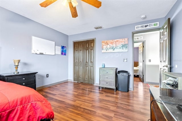 bedroom featuring ceiling fan, dark hardwood / wood-style flooring, and a closet