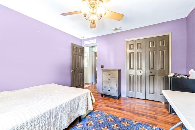 bedroom featuring ceiling fan, dark hardwood / wood-style flooring, and a closet