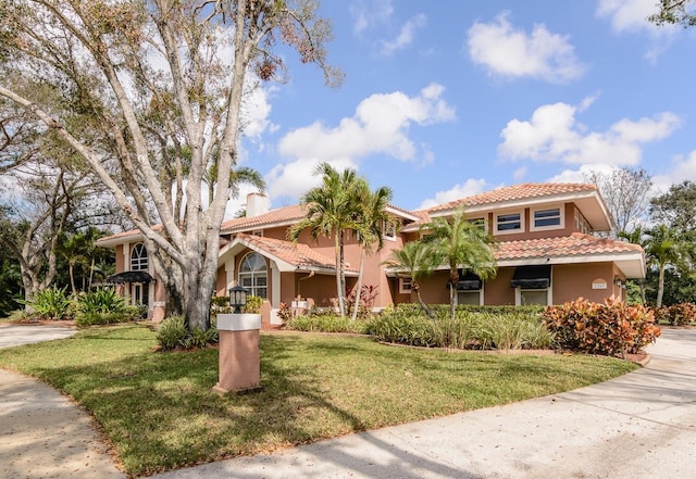 mediterranean / spanish-style house with a front yard