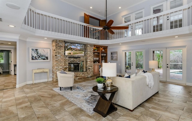 living room with a high ceiling, ornamental molding, a fireplace, and french doors