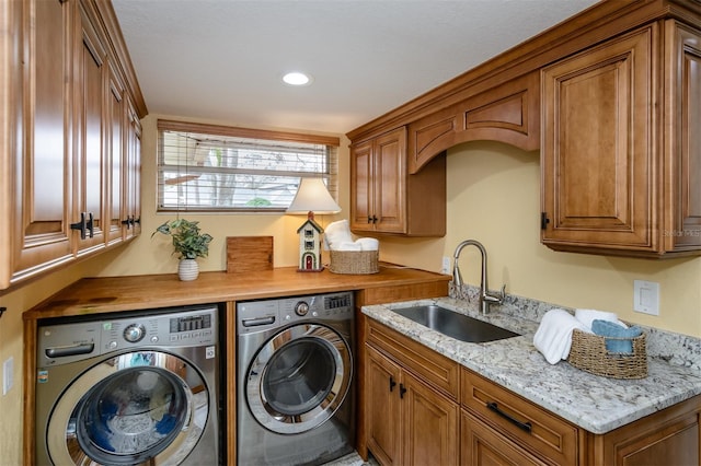 laundry area featuring cabinets, sink, and washer and dryer