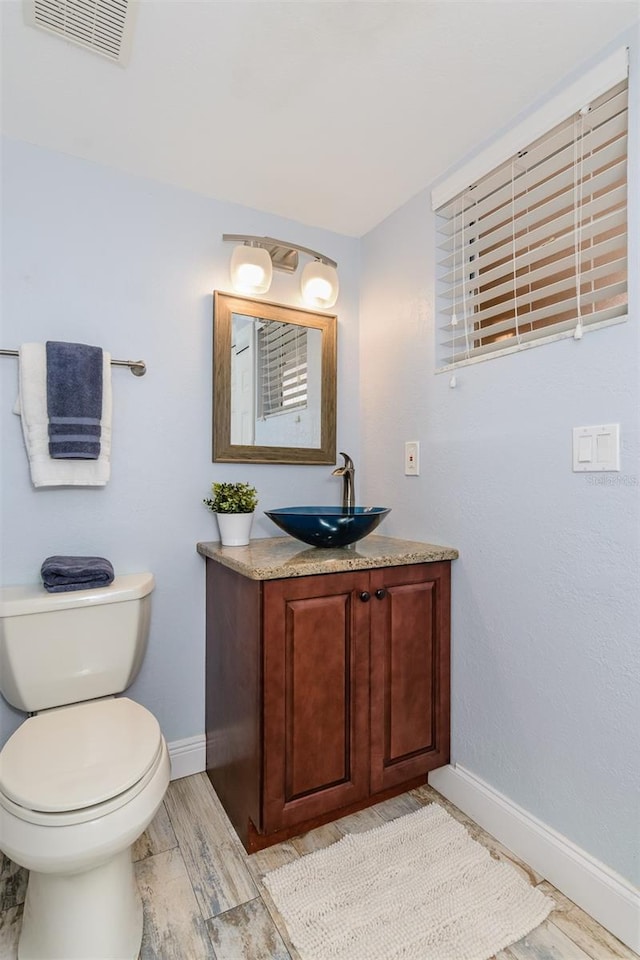 bathroom with vanity, hardwood / wood-style floors, and toilet