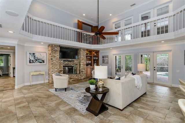 living room with french doors, a fireplace, a high ceiling, and crown molding