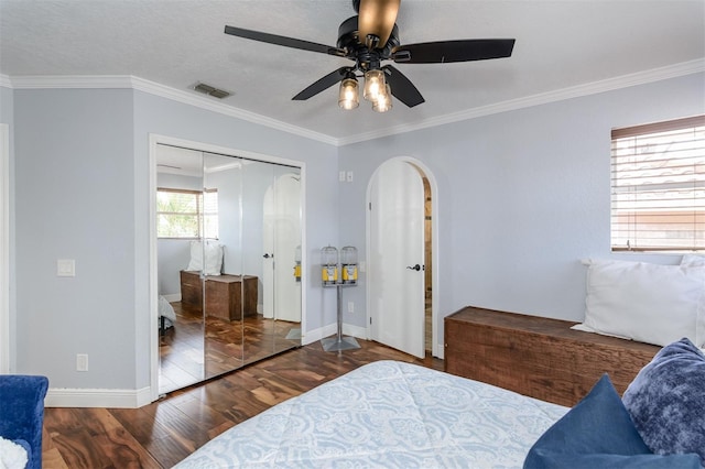 bedroom featuring crown molding, ceiling fan, dark hardwood / wood-style floors, and a closet