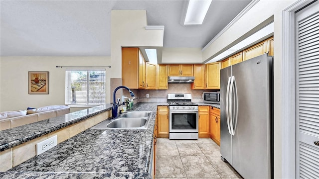 kitchen featuring sink, light tile patterned floors, backsplash, stainless steel appliances, and dark stone counters