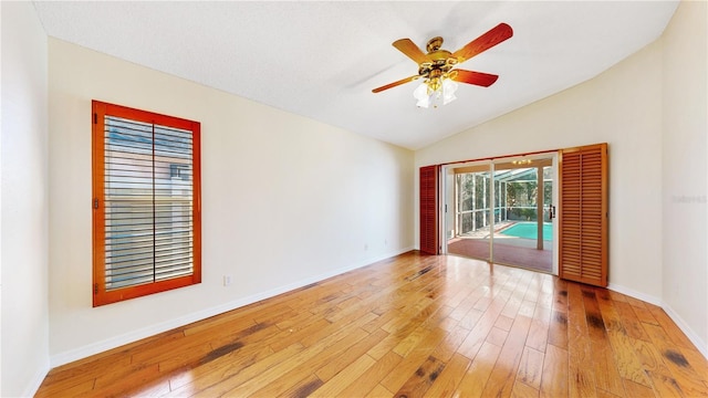 spare room featuring ceiling fan, lofted ceiling, and light hardwood / wood-style floors