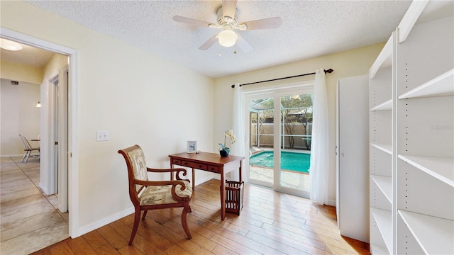 home office featuring ceiling fan, hardwood / wood-style flooring, and a textured ceiling