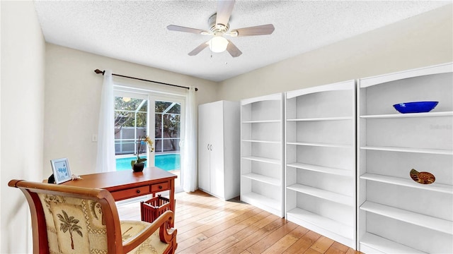 office area featuring ceiling fan, a textured ceiling, and light wood-type flooring