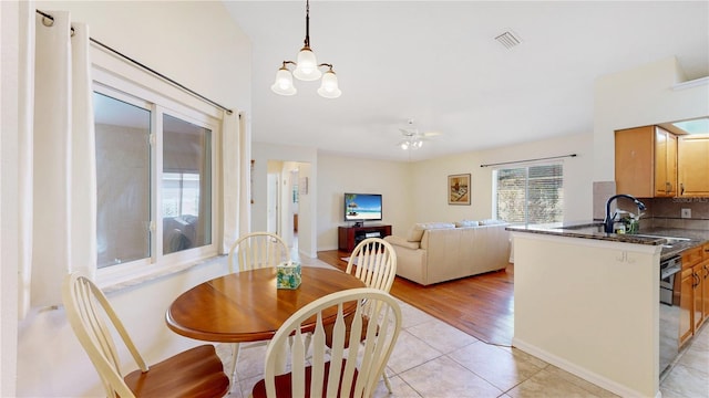 tiled dining room featuring sink and a notable chandelier