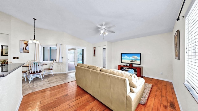 living room with vaulted ceiling, ceiling fan, and light hardwood / wood-style flooring