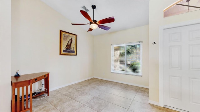 tiled empty room featuring ceiling fan