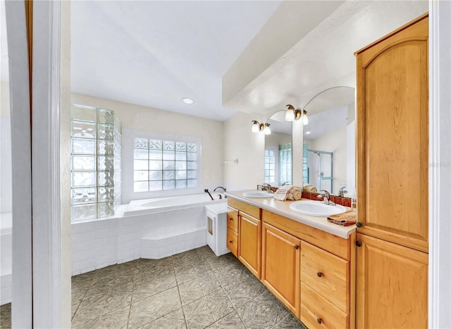 bathroom with a relaxing tiled tub and vanity