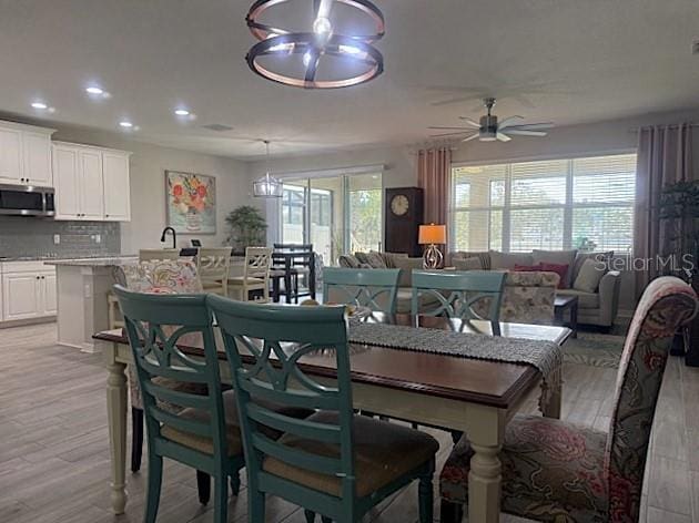 dining space with ceiling fan and light hardwood / wood-style floors