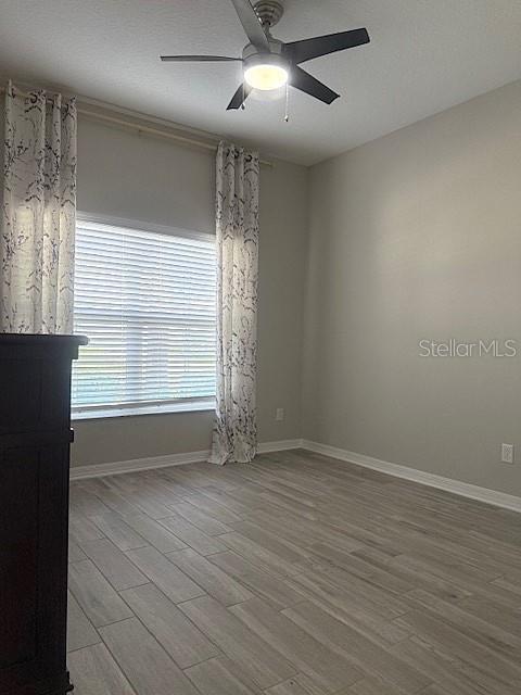 empty room featuring ceiling fan and light hardwood / wood-style floors