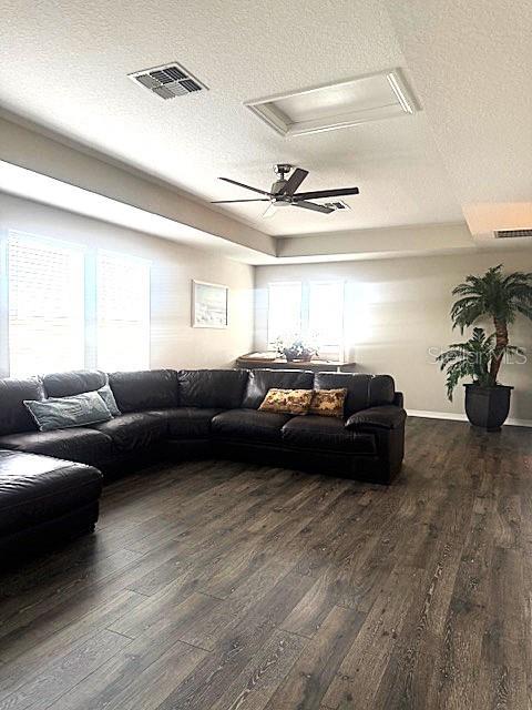 living room featuring dark wood-type flooring and a textured ceiling