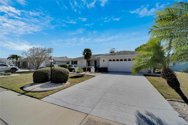 ranch-style home with a garage, concrete driveway, and a front yard