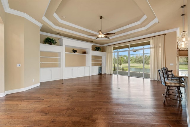 unfurnished living room with dark hardwood / wood-style flooring, a raised ceiling, and ceiling fan