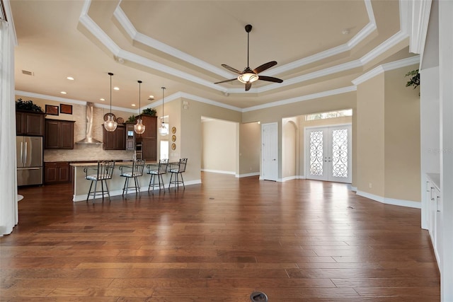 unfurnished living room featuring french doors, ornamental molding, a raised ceiling, and dark wood-type flooring