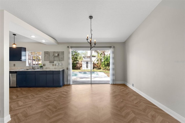 kitchen featuring parquet flooring, sink, decorative light fixtures, a textured ceiling, and dishwasher