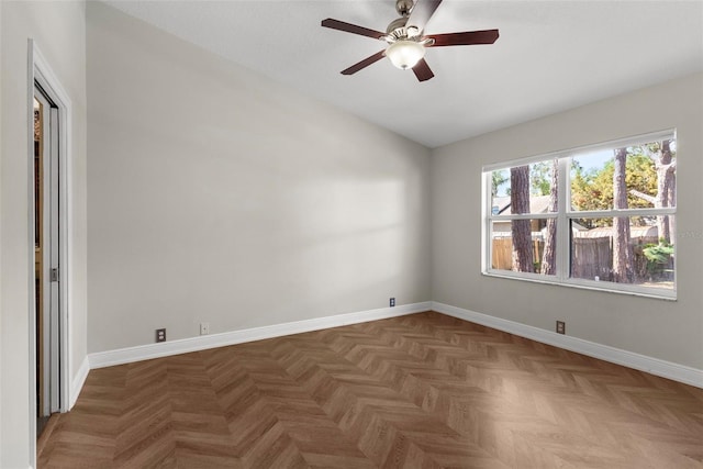 empty room with ceiling fan, lofted ceiling, and dark parquet floors