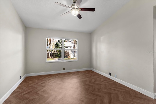 spare room with lofted ceiling, dark parquet floors, and ceiling fan