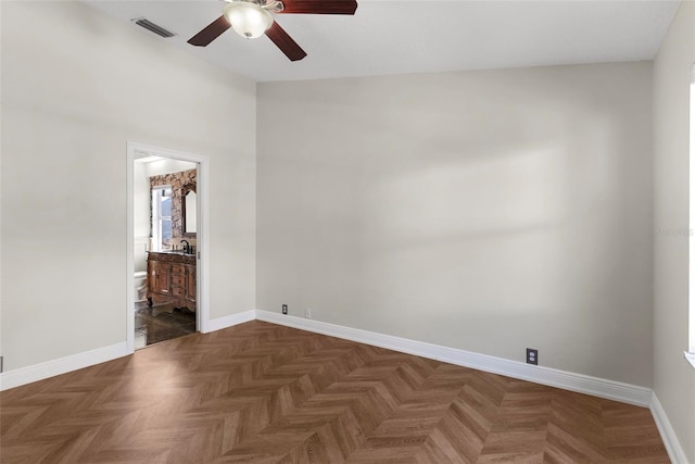 spare room featuring dark parquet flooring and ceiling fan